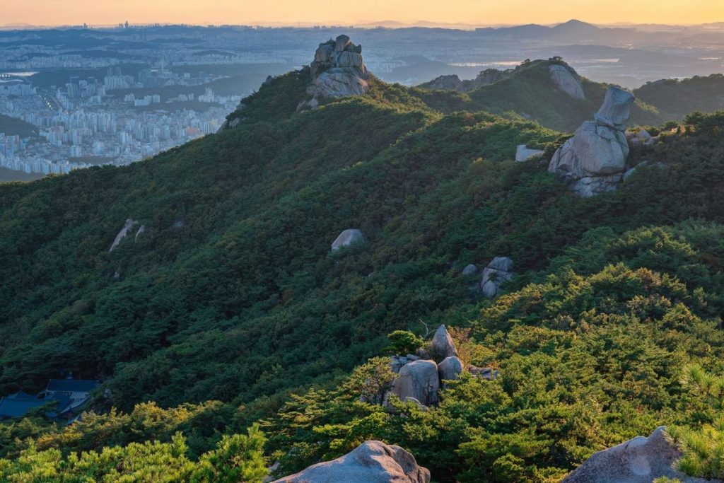 Panorama Gunung Mindung Korea Selatan dengan kolam doline biru yang dikelilingi hamparan padang rumput hijau.